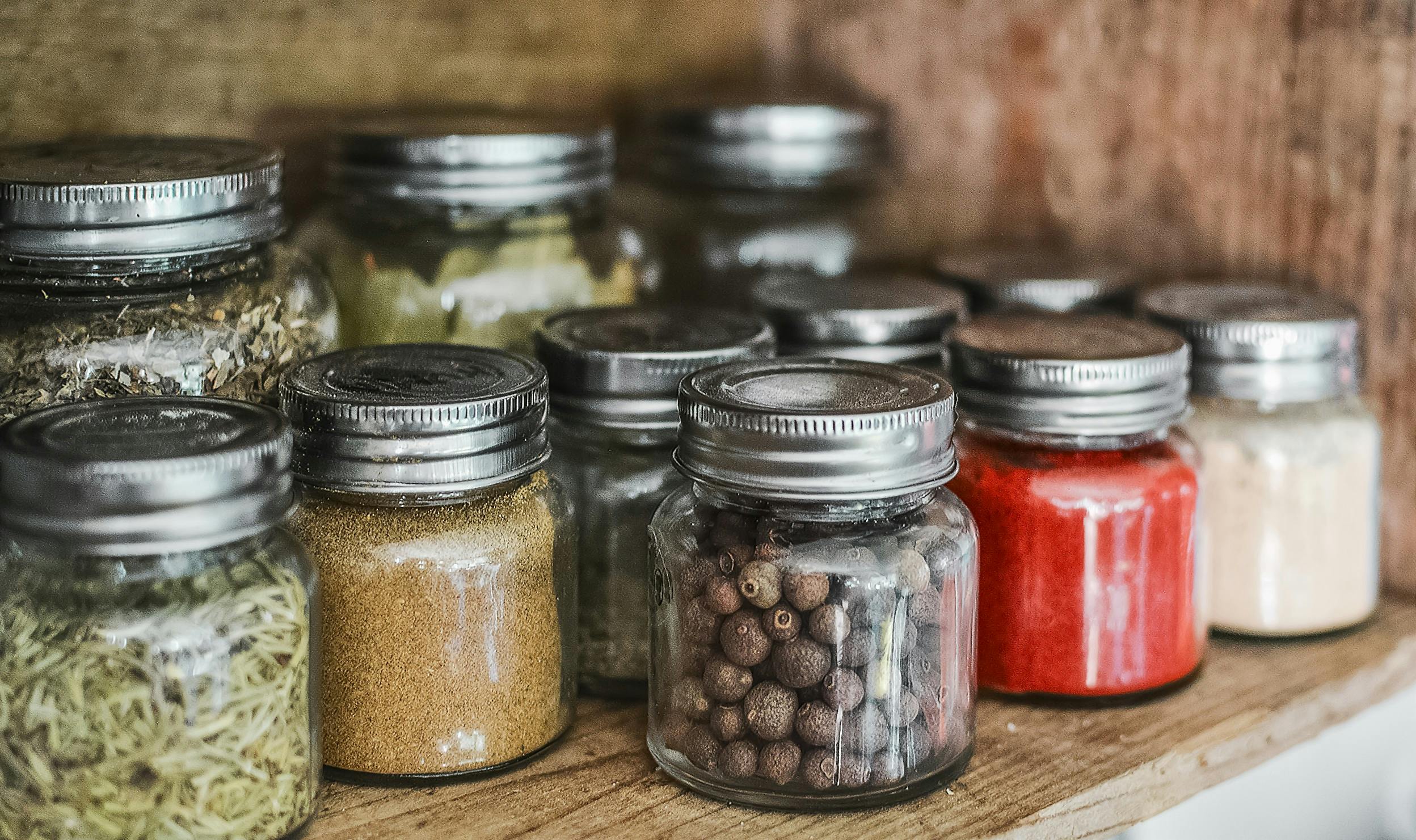 spices in jars displayed on a rustic wooden crate shelf