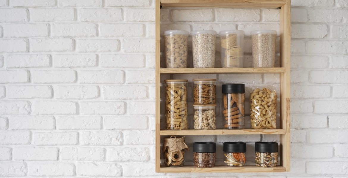 wooden rack with spices in jars mounted on a kitchen wall